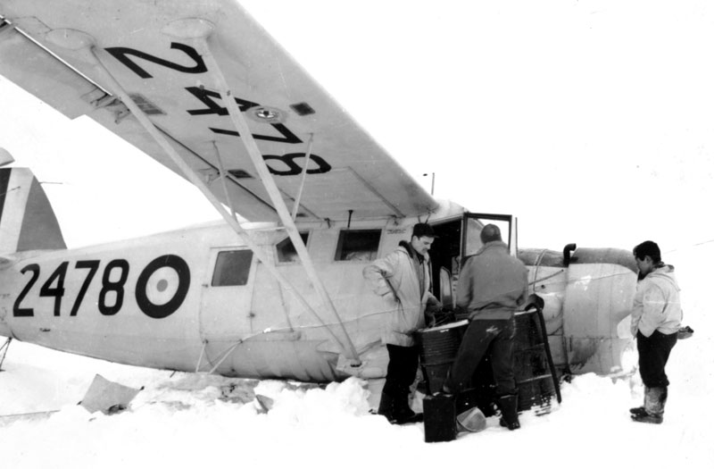 Photo: Captain McVicar inspects crashed Norseman while Inuit man looks on.